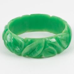 This is a gorgeous milky turquoise marble Bakelite carved bracelet bangle. It features a chunky domed shape with deep geometric carving all around. The color is an intense green marble tone with milky cloudy swirling. Measurements: Inside across is 2.63 in diameter (6.6 cm) - outside across is 3.19 in diameter (8.1 cm) - width is 0.88 in wide (2.2 cm) - The inner circumference of the bracelet is 8.16 in (20.72 cm).  Please see the measurements noted above in the description for the best approxim Green Carved Bracelets As Gift, Green Carved Bracelet For Gift, Green Carved Bracelet As A Gift, Green Carved Round Bangle, Green Carved Bangle Bracelets, Green Carved Bangle Bracelet, Carved Green Jade Bangle, Elegant Carved Green Bangle, Elegant Green Carved Bangle