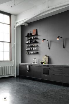 an industrial style kitchen with black cabinets and stainless steel appliances