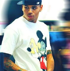 a man with tattoos and a mickey mouse t - shirt