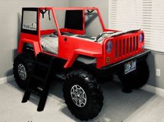 a red toy truck bed in the corner of a room