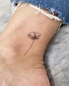 a single flower tattoo on the ankle is shown in black ink, and it has a small