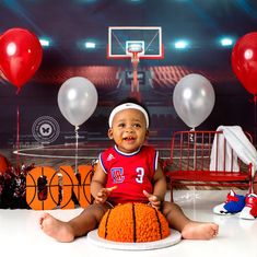 a baby sitting in front of a basketball cake