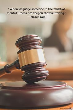 a wooden judge's gavel sitting on top of a table next to a person