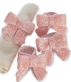 three baby shoes with pink bows on them