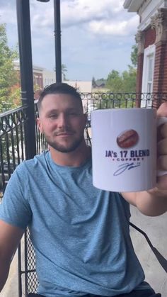 a man holding up a coffee mug in front of his face