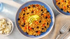 two plates filled with rice, beans and avocado on top of a table