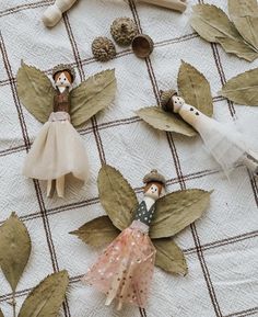 several wooden dolls are sitting on top of leaves