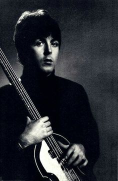 a black and white photo of a man holding a guitar