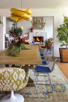 a dining room table with chairs and a fireplace in the background