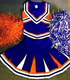 an orange and blue cheerleader uniform with pom - poms on the floor