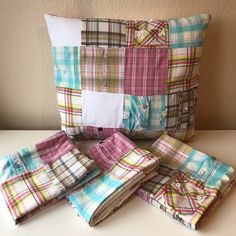 four pillows are stacked on top of each other with different colored plaid patterns in them