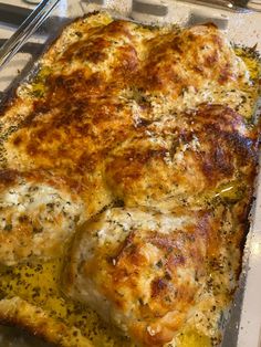 a pan filled with meat covered in cheese and seasoning sitting on top of a table