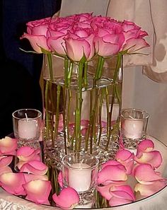 pink flowers in vases and candles on a table