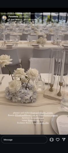 the table is set with white flowers and candles