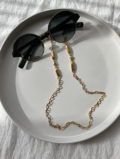 A Gold Glasses Chain in a unique design that is made from stainless steel and i combine it with a unique decoration at the edges with oval metal parts and a special bead that is made from enamel. This chain fits in all glasses designs and its sure that you combine it with all gold colored Glasses or sunglasses. You can select between three available lengths. Find it only at Christina Christi Store. MATERIALS - Chain is made from Stainlees Steel in Gold Color. DIMENSIONS - You can choose in three Glasses Lanyard, Eyeglasses Chain, Glasses Strap, Sunglasses Chain, Colored Glasses, Gold Glasses, Glasses Holder, Unique Decoration, Enamel Beads