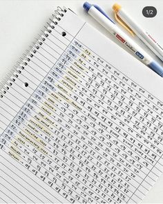 two pens sitting on top of a notebook with chinese characters written in the writing paper