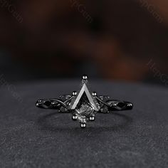 a diamond ring sitting on top of a black table next to a brown and white background