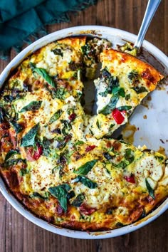 a close up of a pizza in a pan on a wooden table with a slice missing