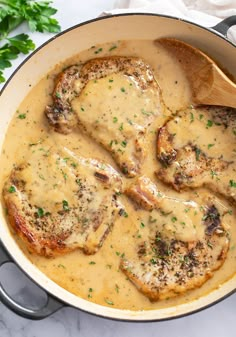 chicken with gravy and parsley in a skillet on a marble counter