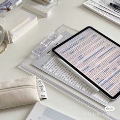 a tablet computer sitting on top of a desk next to a watch and other office supplies