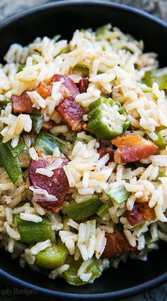 rice with bacon and asparagus in a black bowl on top of a table