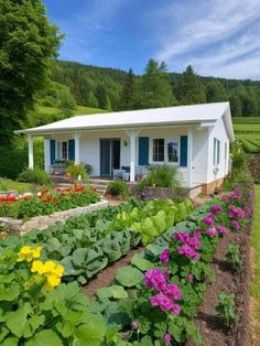 a white house surrounded by flowers and greenery