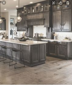 a large kitchen with wooden floors and gray cabinets