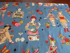 a blue table cloth with images of women playing cards and other things on the table