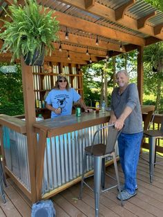 two men are standing at the bar outside