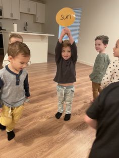 three children holding up a sign that says sup on it in front of them