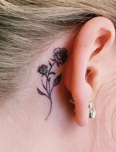 a small flower behind the ear tattoo