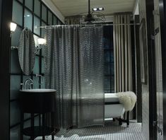 a bath room with a toilet a sink and a shower head mounted to the side of a wall