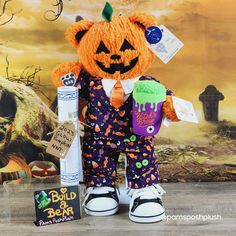 a teddy bear dressed up as a halloween pumpkin holding a cupcake and candy bar