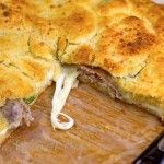 a meat and cheese pie on a cutting board