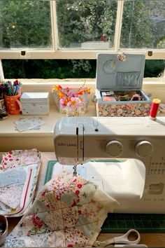 a sewing machine sitting on top of a table next to some scissors and other crafting supplies