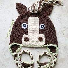 a crocheted brown and white hat with a horse's head on it