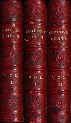 four red leather books sitting on top of each other