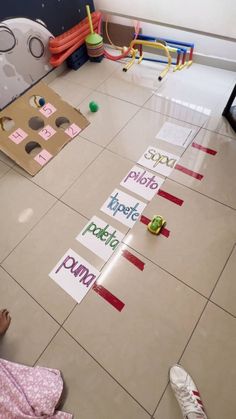 a child is sitting on the floor and playing with some paper cut out to spell words