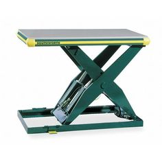 a green and yellow scissor sitting on top of a wooden table with wheels