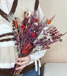 a woman holding a bouquet of flowers in her hands