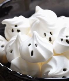 a black bowl filled with marshmallows on top of a table