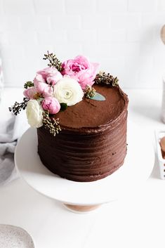 a chocolate cake with pink and white flowers on top