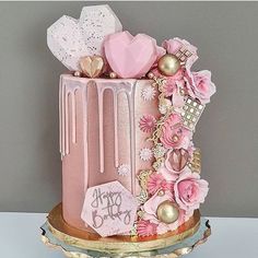 a pink and gold cake with hearts on it's top is displayed for instagram