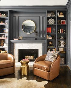 a living room with two leather chairs and a fireplace