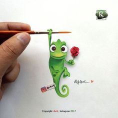 a hand holding a pencil and drawing a green gecko with red roses on it