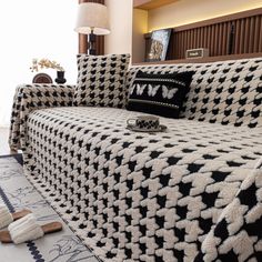 a couch covered in black and white blankets