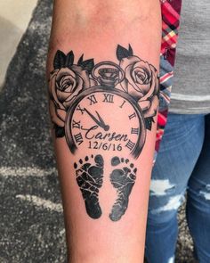 a person with a tattoo on their arm has a clock and baby's footprints