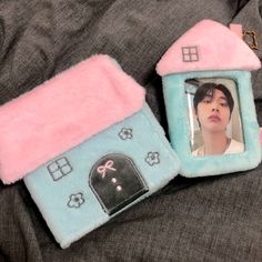 two small houses with pictures on them sitting on top of a bed next to each other