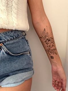 a woman's arm with a flower tattoo on the left side of her body