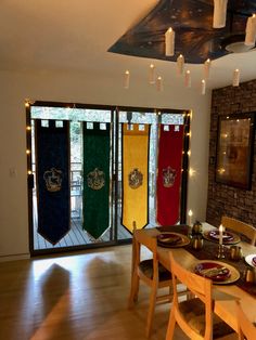 a dining room table with place settings and flags on the door to another room that has glass doors